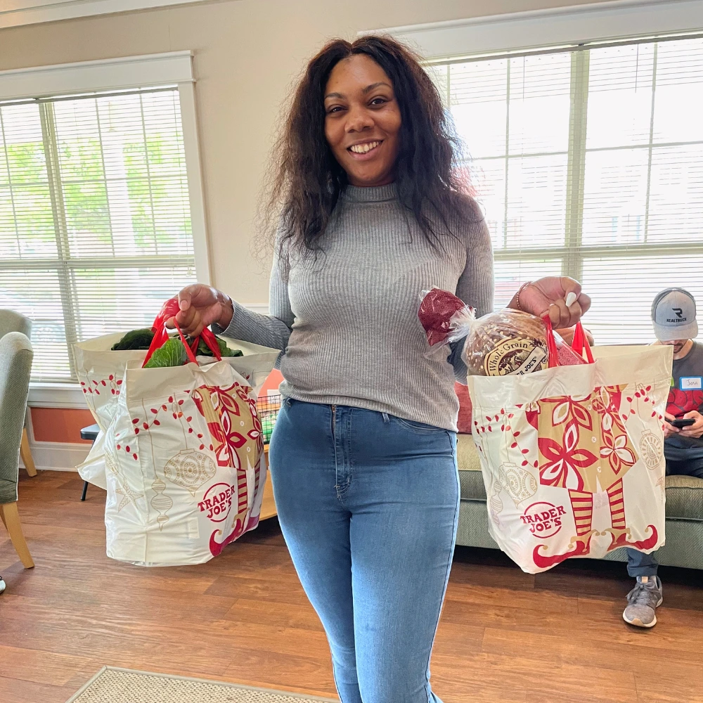 Woman holding up two grocery bags and smiling