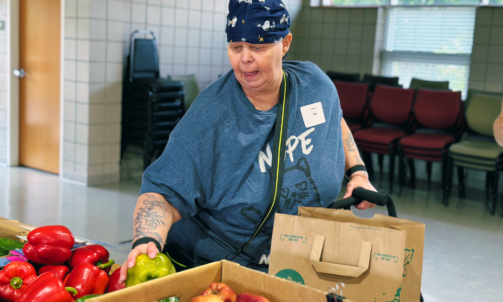 Cancer patient selecting a bell pepper at a market